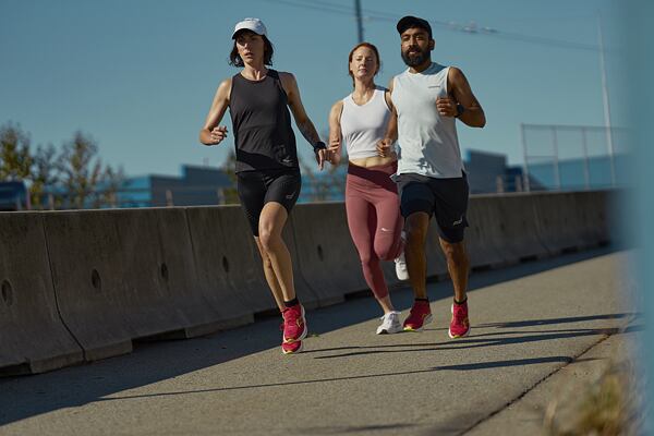 Běžci ve městě s běžeckými botami Saucony