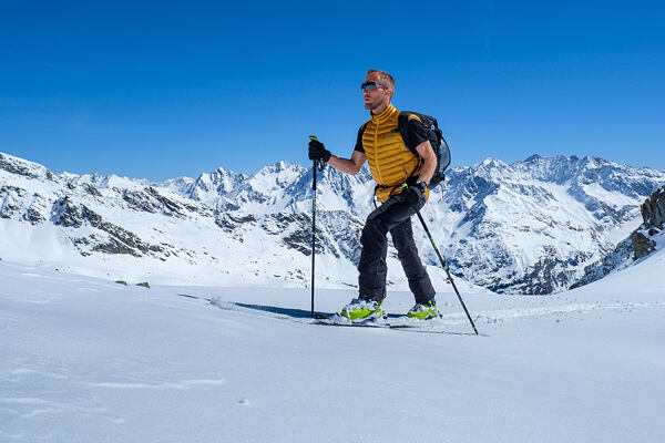 Muž v zimním oblečení a sofstshellových kalhotech
