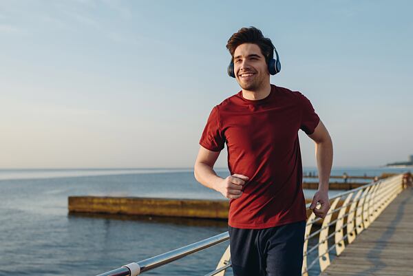 Muž sportující u moře v merino tričku