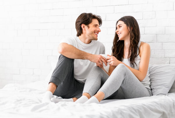 Pár ležící v posteli v teplákách