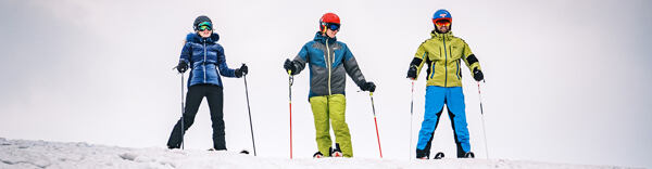 Lyžaři na svahu v lyžařském oblečení